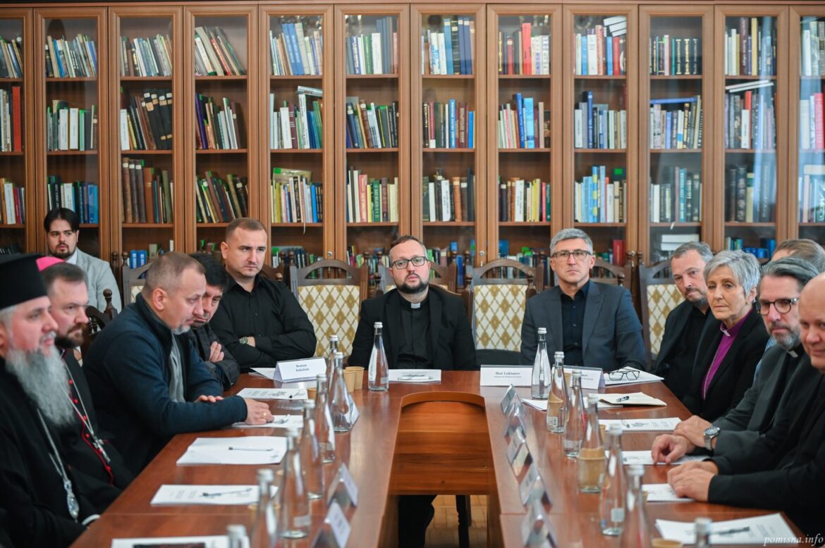 Учасники зустрічі за довгим столом у бібліотеці, серед них Митрополит Епіфаній, таблички з іменами на столі